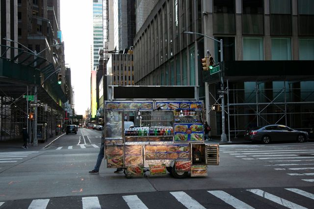 Food truck vendor pushes his cart down an empty street near Times Square in New York.